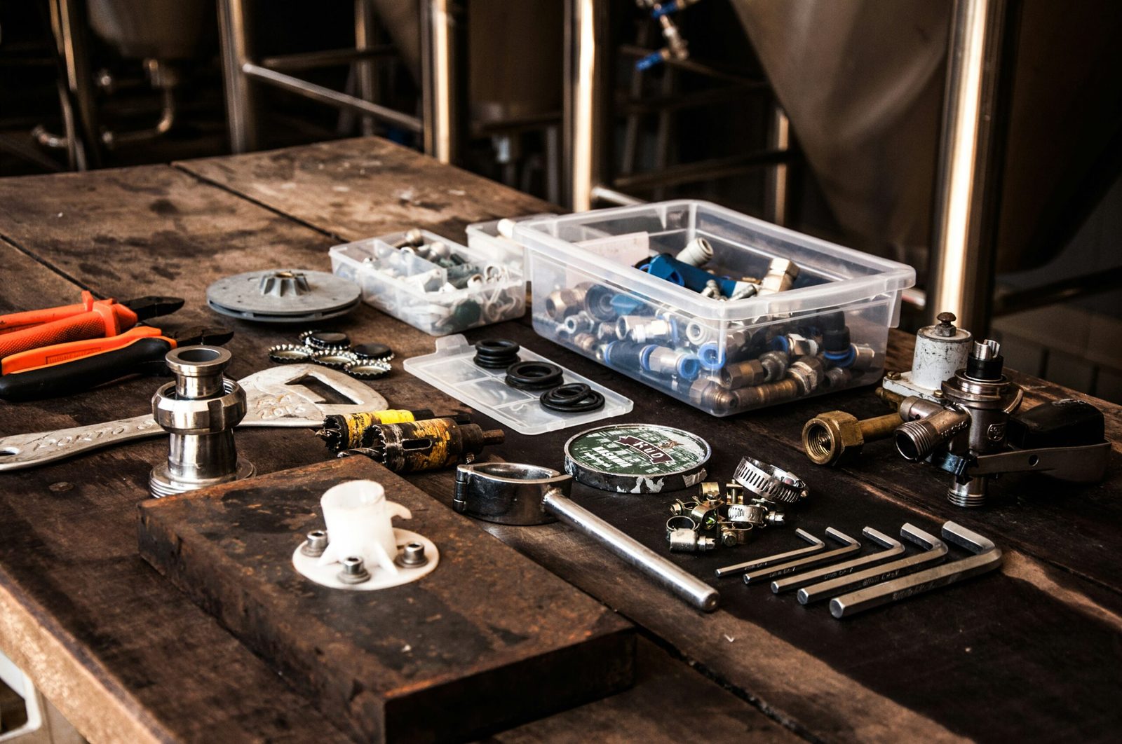 Plumbing fittings, valves and tools laid out on a workshop bench